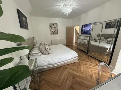 a bedroom with a bed and a flat screen tv at Southend Apartment With Parking, Private Garden and Beach Side Location in Southend-on-Sea