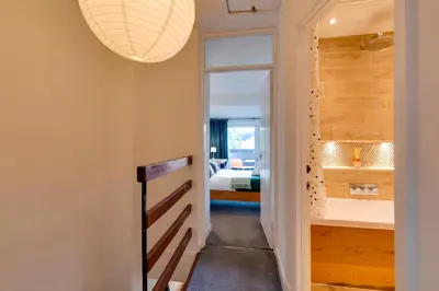 a hallway with a bathroom with a tub and a bedroom at Modern and Stylish Townhouse in City Centre Pass the Keys in Cambridge