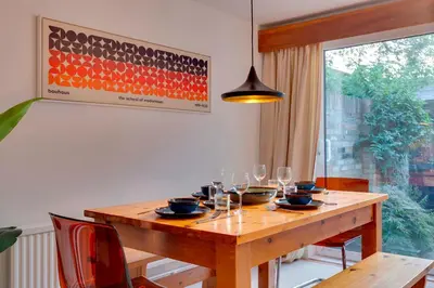 a dining room table with wine glasses and a pendant light at Modern and Stylish Townhouse in City Centre Pass the Keys in Cambridge