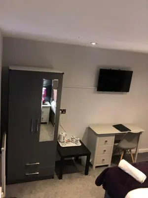 a room with a bedroom with a desk and a mirror at OYO Watton Vibe Hotel in Watton