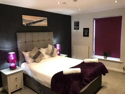 a bedroom with a large bed and two lamps at OYO Watton Vibe Hotel in Watton