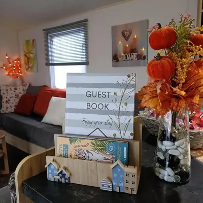 a guest book sign on a table in a living room at Centrix at Seawick Holiday Park in Saint Osyth
