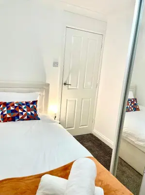a bedroom with a mirror next to a bed at Relaxed Leigh-on-Sea Escape, Family-Friendly & Contractor Stays in Hockley