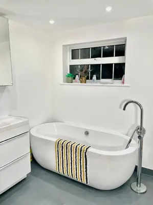 a white bath tub in a bathroom with a window at Relaxed Leigh-on-Sea Escape, Family-Friendly & Contractor Stays in Hockley