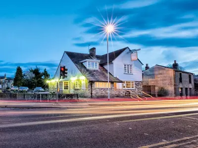 a house on the corner of a street with a traffic light at The Porterhouse Pub & Restaurant Cambridge in Willingham