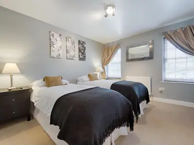 a bedroom with two beds and a mirror on the wall at The Porterhouse Pub & Restaurant Cambridge in Willingham