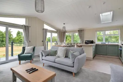 a living room with a couch and a table at Finest Retreats - Cambridge Luxury Lodge