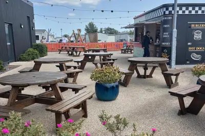 a group of picnic tables and a pot of flowers at Seaside Lodge Haven in St Osyth in Jaywick Sands