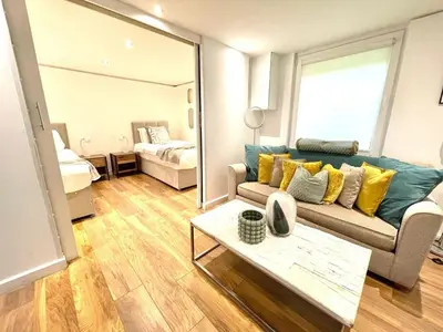 a living room with a couch and a bedroom at Historical Building - Cozy Basement Apartment- Central Location in Cambridge