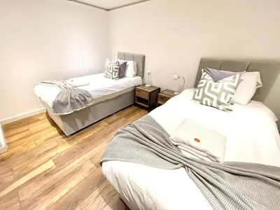 a bedroom with two beds with a laptop on it at Historical Building - Cozy Basement Apartment- Central Location in Cambridge