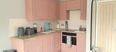 a kitchen with pink cabinets and a counter top at Lily Lake Lodge in Chelmsford