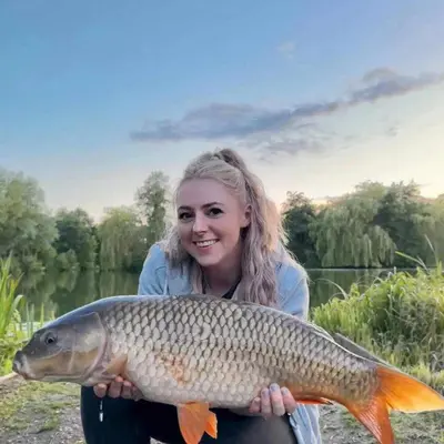 a woman holding a large fish in her hands at Lily Lake Lodge in Chelmsford