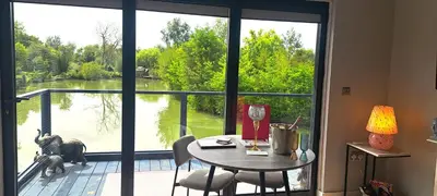 a room with a table and a large window at Lily Lake Lodge in Chelmsford