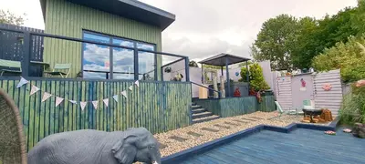 a house with a elephant standing in front of a fence at Lily Lake Lodge in Chelmsford