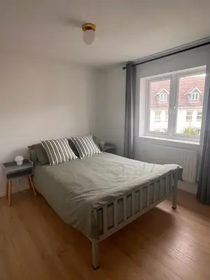 a bed in a bedroom with a large window at La CAZA Guest House in Royston