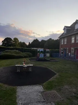a playground in a yard with a house and a house at La CAZA Guest House in Royston
