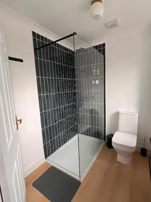 a glass shower in a bathroom with a toilet at La CAZA Guest House in Royston