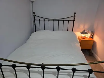 a bed in a bedroom with a lamp on a night stand at Stay Near Colchester twn centre3 in Hythe