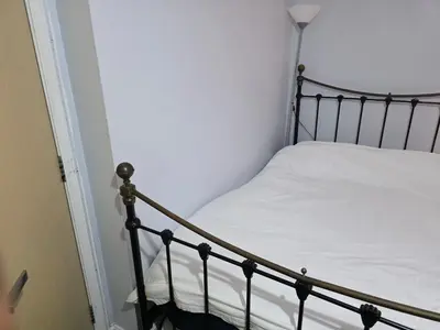 a bedroom with a bed with white sheets and a lamp at Stay Near Colchester twn centre3 in Hythe