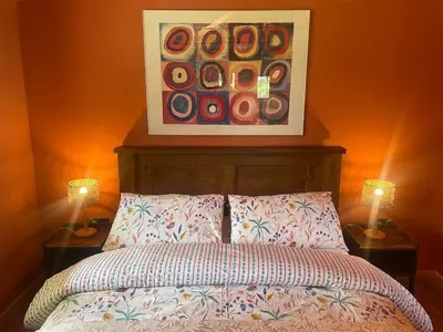 a bedroom with a bed with two lamps and a painting at Okovango Cabin in Holton