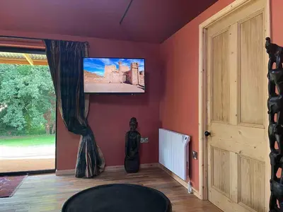 a living room with a flat screen tv on the wall at Okovango Cabin in Holton