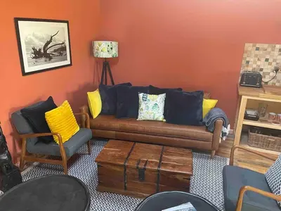 a living room with a couch and some chairs at Okovango Cabin in Holton