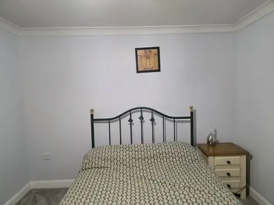 a bedroom with a bed and a clock on the wall at Stay Near Colchester twn centre2 in Colchester