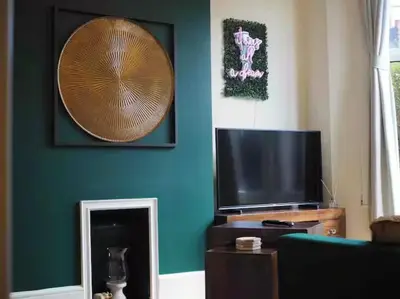 a living room with a flat screen tv and a mirror at Contractors, Long stay,WI-Fl, Garden, parking in Chelmsford