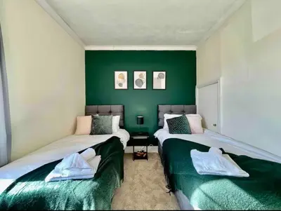 two beds in a room with green walls at Contractors, Long stay,WI-Fl, Garden, parking in Chelmsford