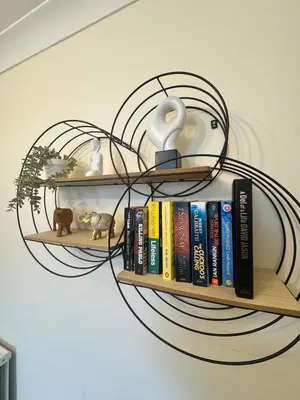 a book shelf with books and a fan at Contractors, Long stay,WI-Fl, Garden, parking in Chelmsford