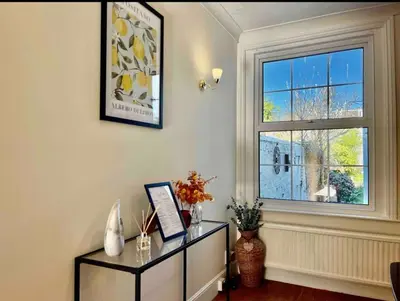 a room with a window and a dresser with a picture at Contractors, Long stay,WI-Fl, Garden, parking in Chelmsford