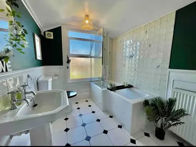 a bathroom with a tub and a sink and a bath tub at Contractors, Long stay,WI-Fl, Garden, parking in Chelmsford