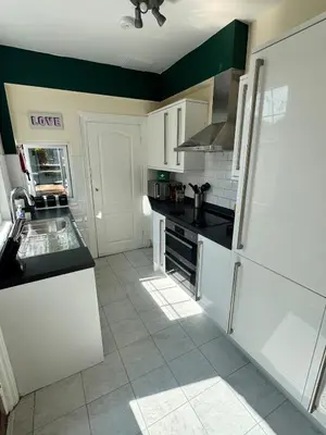 a kitchen with white cabinets and a white refrigerator at Contractors, Long stay,WI-Fl, Garden, parking in Chelmsford