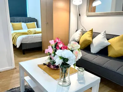 a living room with a vase of flowers on a table at Cosy Studio in Stevenage