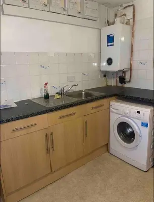 a kitchen with a sink and a washing machine at Cosy Studio in Stevenage