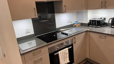 a kitchen with a stove and a microwave at Jewel of Chelmsford in Chelmsford
