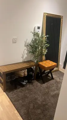 a table and a bench in a room with a mirror at Jewel of Chelmsford in Chelmsford