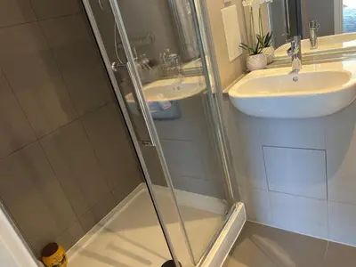 a bathroom with a shower and a sink at Jewel of Chelmsford in Chelmsford