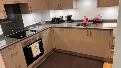 a kitchen with a stove and a sink at Jewel of Chelmsford in Chelmsford