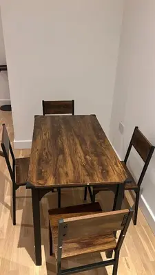 a wooden table and two chairs and a wooden table and chairs at Jewel of Chelmsford in Chelmsford