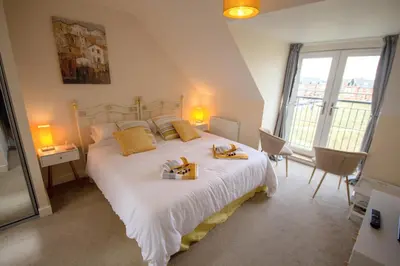a bedroom with a large white bed with towels on it at Martello Sunrise - Luxury 3-bedroom Seaview Beach House in Felixstowe