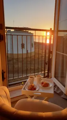a table with two plates of food on a balcony at Martello Sunrise - Luxury 3-bedroom Seaview Beach House in Felixstowe