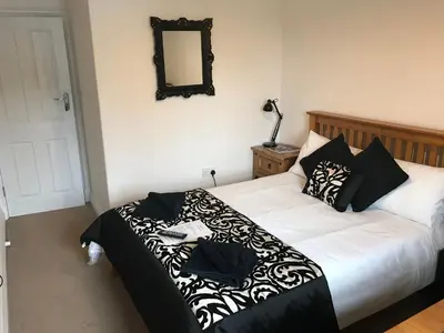 a bedroom with a bed with black and white pillows at Beightons Bed and Breakfast in Bury Saint Edmunds