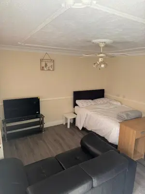 a living room with a bed and a couch at Fully en-suite with kitchen