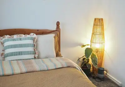 a bedroom with a bed with a pillow and a lamp at Cosy Room in Debenham in Debenham