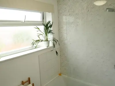 a bathroom with a plant sitting on a window sill at Cosy Room in Debenham in Debenham