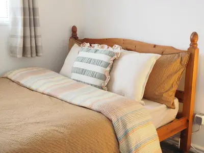 a bed with pillows on it in a bedroom at Cosy Room in Debenham in Debenham