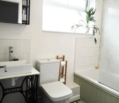a bathroom with a toilet and a sink and a tub at Cosy Room in Debenham in Debenham