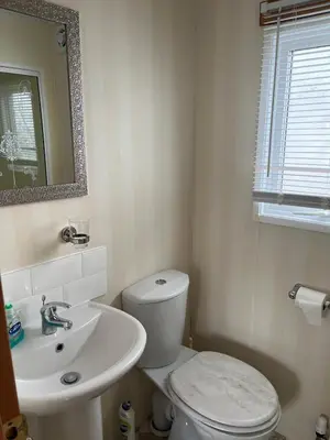 a bathroom with a white toilet and a sink at 2 Bedroom Mini Lodge near the beach in Walton-on-the-Naze