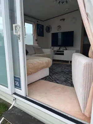 a living room with a couch and a tv at 2 Bedroom Mini Lodge near the beach in Walton-on-the-Naze